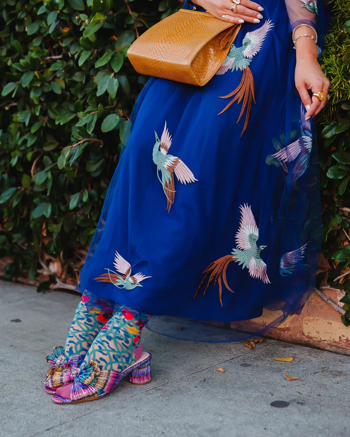 Model demonstrates how to style vine and floral-patterned sheer socks with colorful shoes, dress & accessories