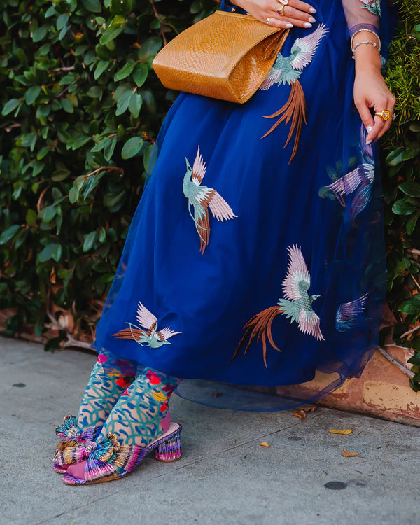 Model demonstrates how to style vine and floral-patterned sheer socks with colorful shoes, dress & accessories