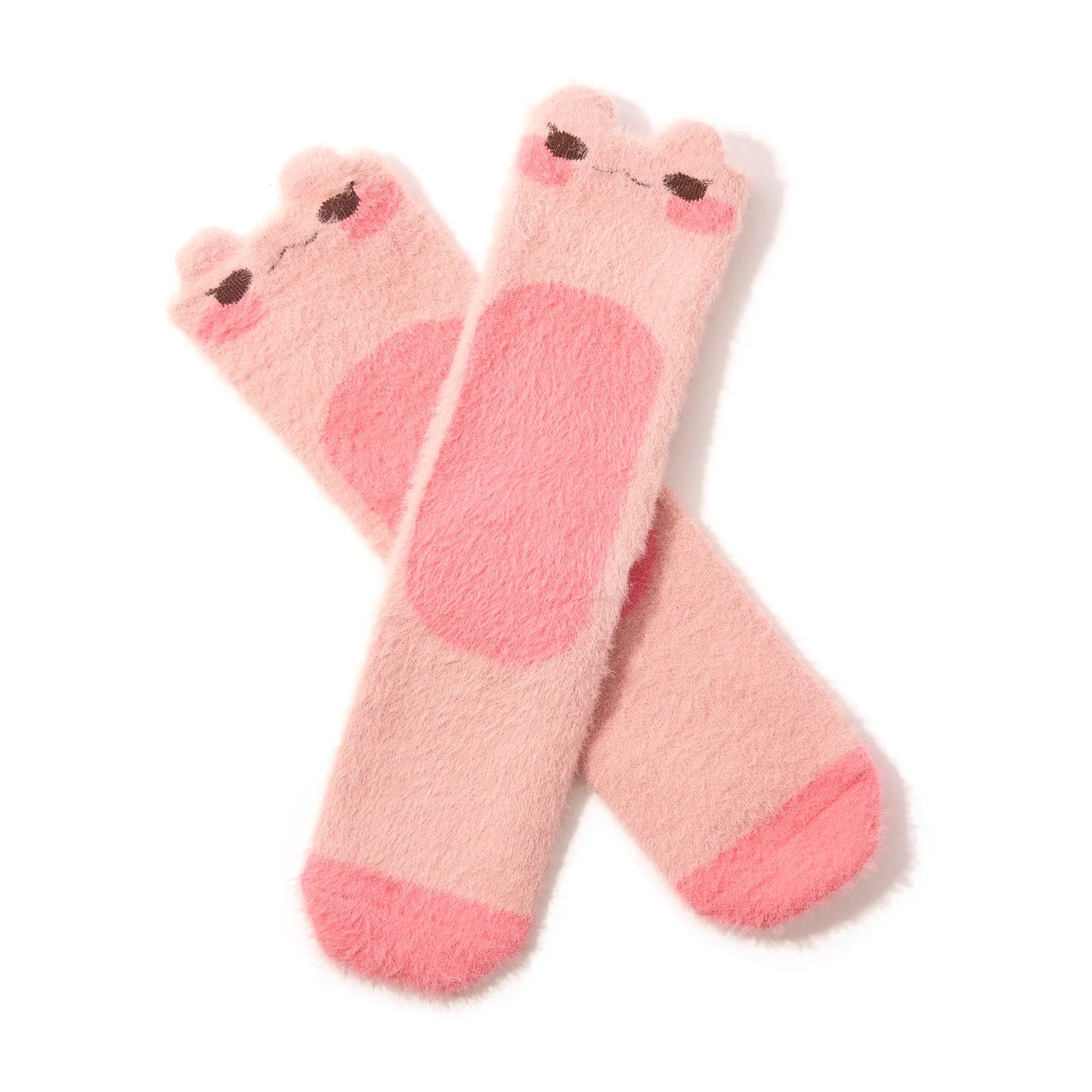 A pair of pink fuzzy crew socks with blushing frog faces at the top is shown in flatlay on a white background.