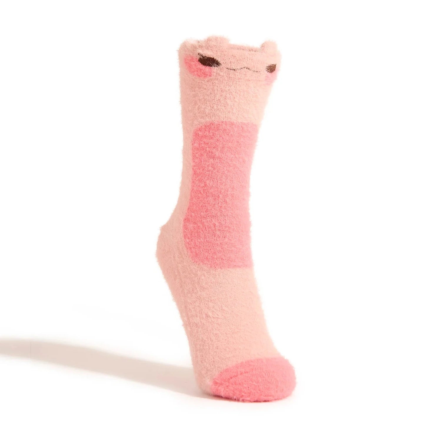 A pink fuzzy crew sock with a blushing frog face at the top is shown on a foot form against a white backdrop.