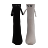 Black sock and white sock with eyes and 3d arms hold hands