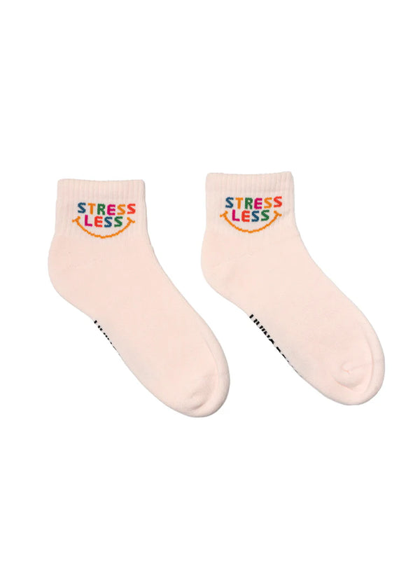 Pair of light orange socks with 'STRESS LESS' smiley text on a white background