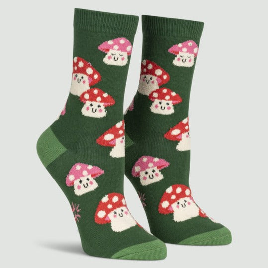 green socks on leg forms featuring red and pink mushrooms with little happy faces and pink cheeks