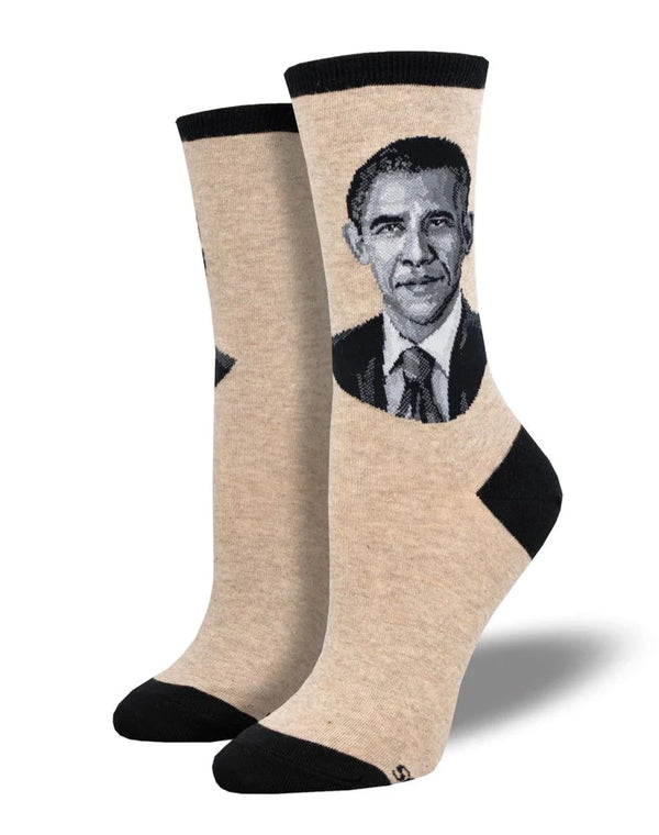 a pair of heather beige socks with a black toe heel and cuff featuring a portrait of president obama on the side of the leg