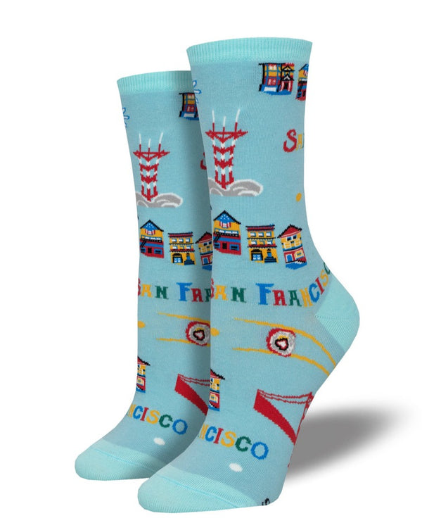 light blue socks on leg forms featuring text that reads SAN FRANCISCO in many different colors and various san francisco icons like sutro tower, the painted ladies, sushi, and the golden gate bridge