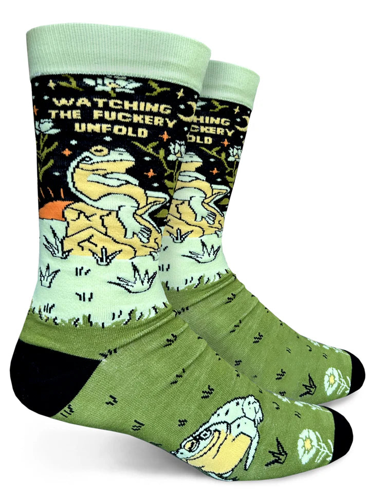 Black and green sock featuring a frog sitting on a rock & text that reads 