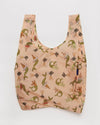 a light pink reusable shopping back with a print of illustrations of rabbit mermaids and small bunches of carrots