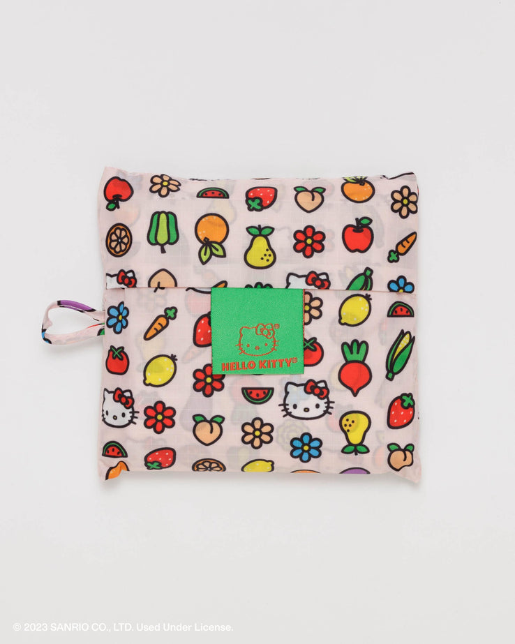 a white nylon shopping bag printed with cartoon style illustrations of hello kitty's face, fruit and flowers