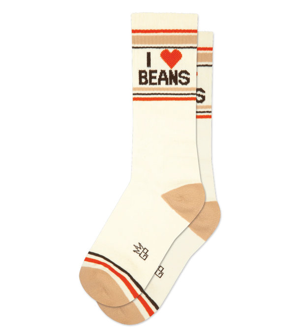 In flatlay, pair of cream crew socks with tan heel & toe; brown, tan & orange stripe patterns; and brown text that reads "I 🧡 BEANS"