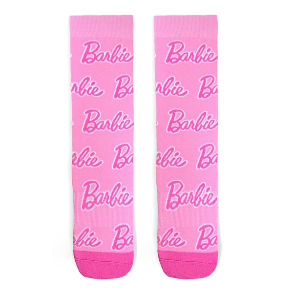 Shown in a flatlay, a pair of pink Barbie socks with a hot pink heel and toe. These cotton socks have the classic Barbie script written all over the sock. 