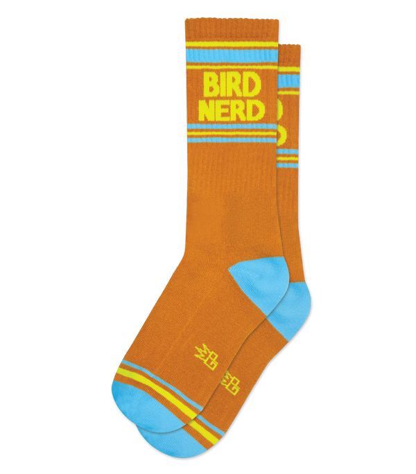 In flatlay, a pair of butterscotch socks with light blue heels and toes, blue and neon yellow stripe patterns near the toe and ankle, and neon yellow text that reads "Bird Nerd"