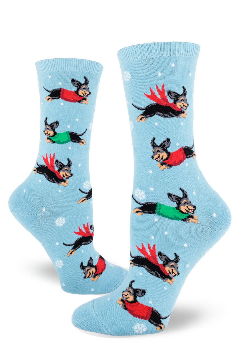 Light blue socks with dachshund dogs wearing sweaters and scarves in a snowy scene