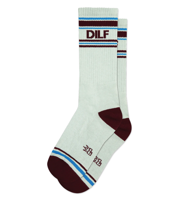 A pair of light gray socks sits in flatlay. They have maroon heels and toes, maroon & light blue stripe patterns at the toe and and ankle, and maroon text that reads "DILF"