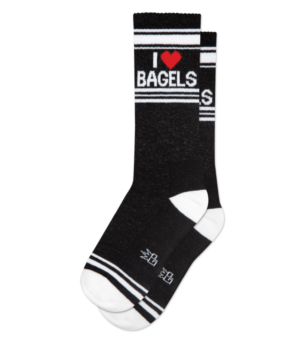 In flatlay, two black crew socks with white heel, toe & stripe pattern on leg with white text that reads "I ❤️ BAGELS"