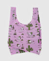 A pink canvas bag with cactuses and cartoon dog Spike engaged in various activities