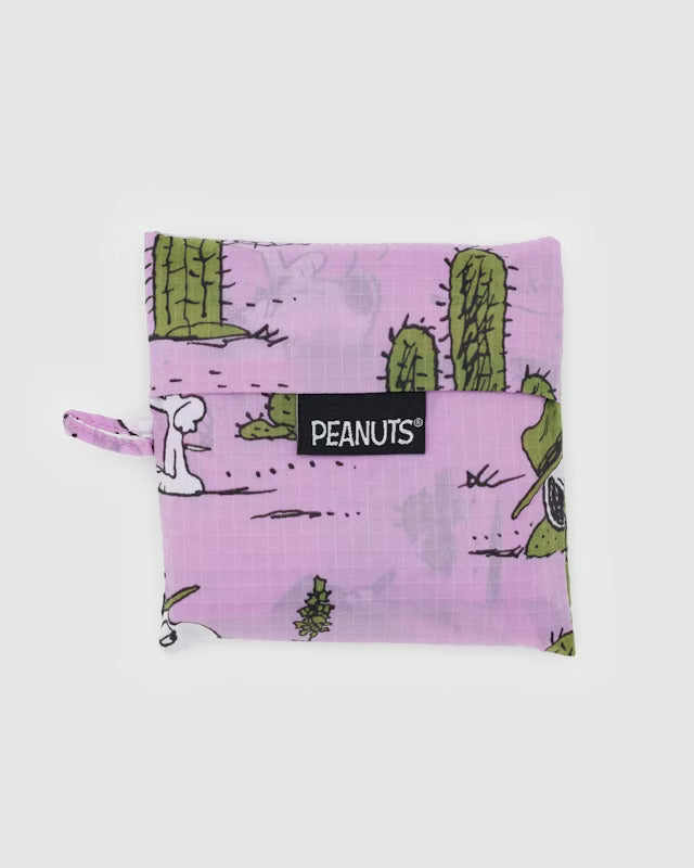 A pink canvas pouch with cactuses and cartoon dog Spike engaged in various activities. A black tag reads 