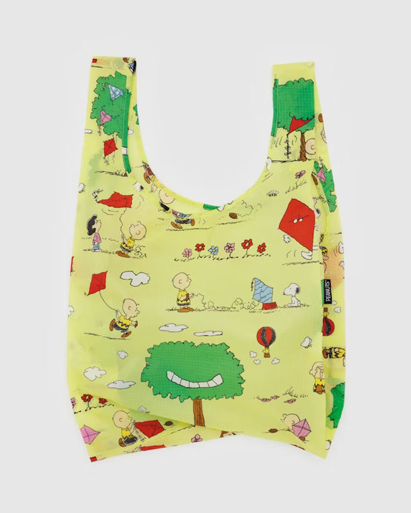 Yellow canvas bag with characters from peanuts attempting to fly kites, hot air balloons and a kite-eating tree