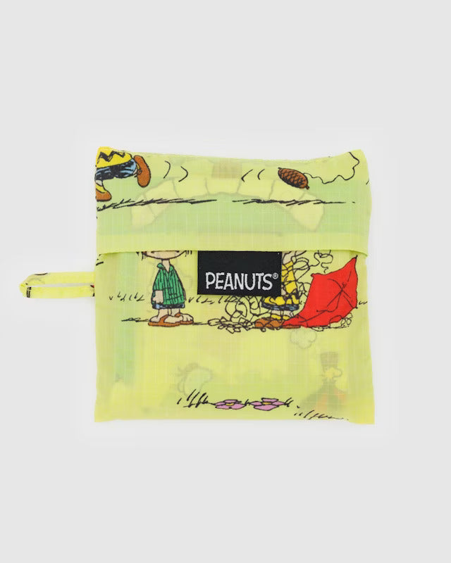 Yellow canvas pouch with characters from peanuts attempting to fly kites, hot air balloons and a kite-eating tree. A black tag reads 