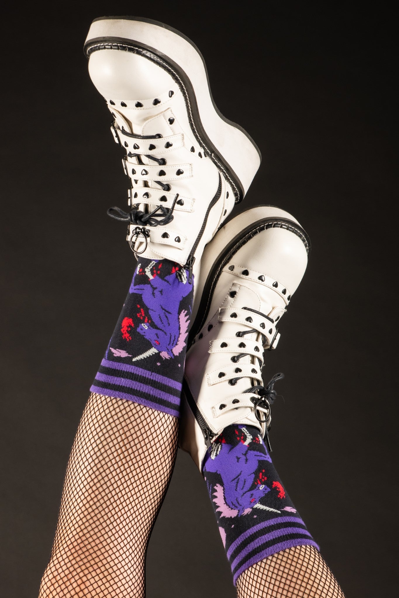 Shown on a model's legs in fishnets and gothic white sneakers, the Evil AF Unicorn socks.
