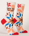 a pair of foot forms showing cream socks with a red toe and heel with black text that reads "aunts are the shit" and folk are inspired decorative shapes in blue, brown and black