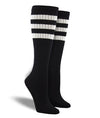 Shown on leg forms, these black cotton unisex tall crew socks by the brand Socksmith have three white stripes at the top of the sock hugging the calf.