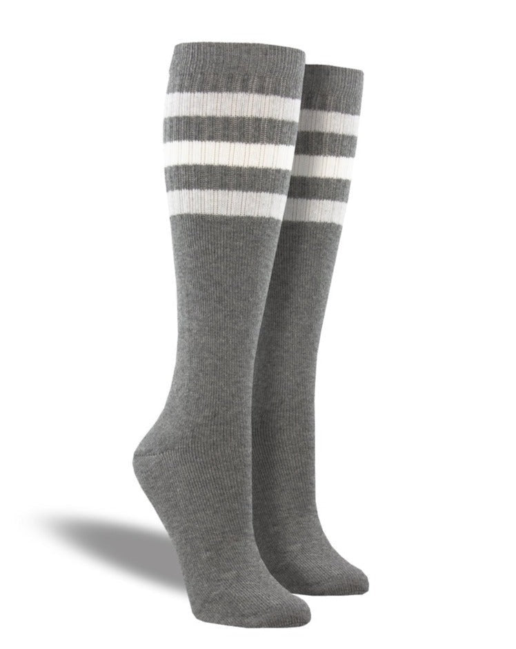 Shown on a leg form, these heathered gray cotton unisex tall crew socks by the brand Socksmith have 3 white horizontal stripes hugging the calf.