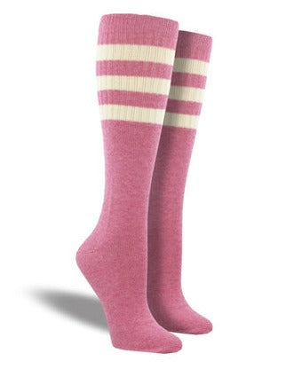 Shown on a leg form are medium pink heather tall crew length socks featuring three ivory stripes at the top hugging the calf.