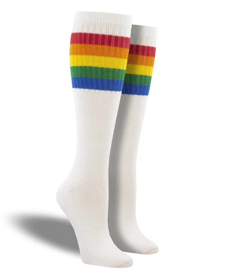 Shown on a leg form, these white cotton unisex tall crew socks by the brand Socksmith have a a rainbow of horizontal stripes hugging the calf.