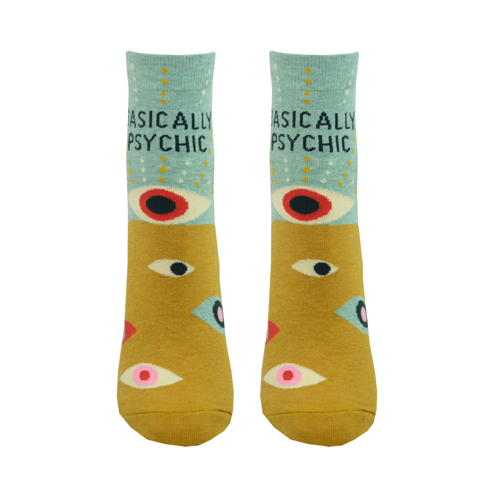 Shown on a leg from the front, a pair of Blue Q cotton women’s quarter length socks with mustard yellow and mint green background, mysterious eyes pattern, and “Basically Psychic” text