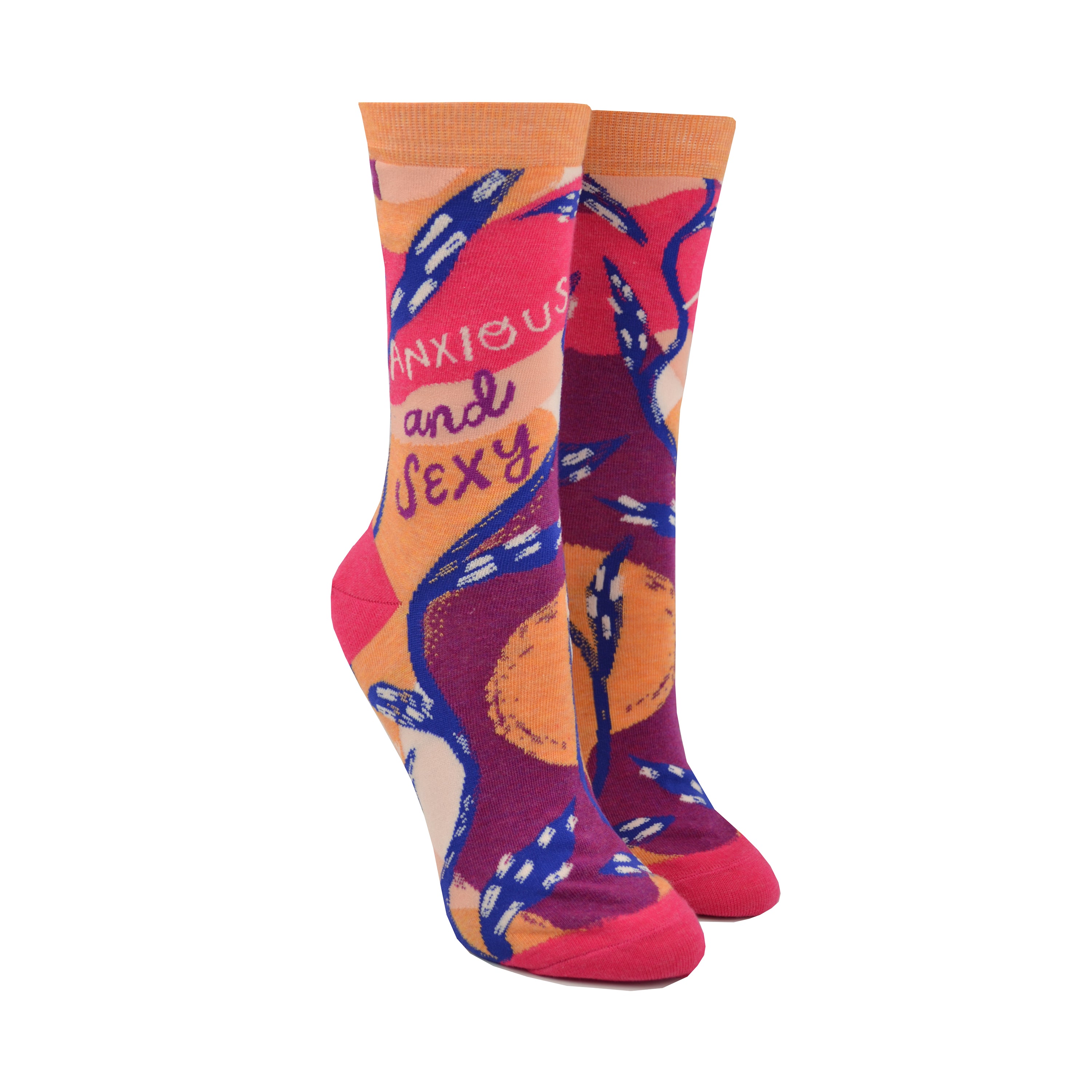 Shown on leg forms, a pair of Blue Q brand women's cotton crew socks with a hot pink heel and toe with an orange cuff. The sock has an abstract design of hot pink, light pink, orange, and purple with a blue vine weaving around the sock. On the leg in a cursive font the sock reads, 