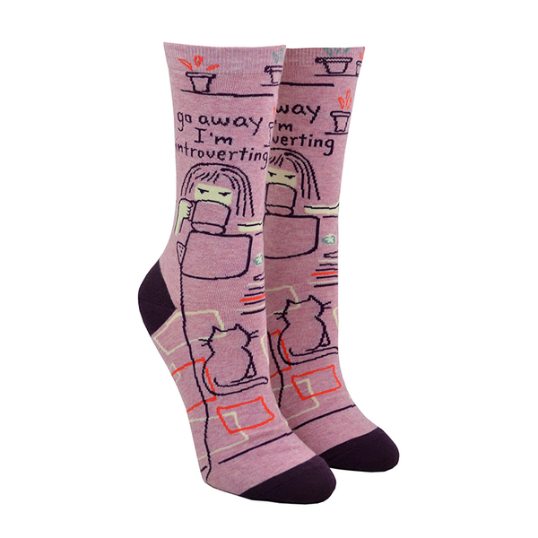 A cartoonish girl is shown sipping coffee in front of her computer while the words "Go away I'm introverting" are written above her on this magenta women's cotton crew sock by Blue Q.