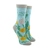 Shown on leg forms, a pair of light blue Blue Q socks with a grey heel, toe, and cuff. The feature a dandelion and puffball design on the foot and the phrase, "I never fart" on the leg. 