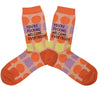 A pair of orange socks that have a retro geometric pattern in orange, lilac and, yellow. The socks have text that reads, "You're Fucking Welcome Everybody." on the leg. 