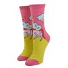 Shown on a leg form, these pink cotton women's crew socks by the brand Blue Q feature a unicorn standing on a yellow hill in front of a blue cloud and yellow stars with the quote "Always be yourself" on the leg, continuing "unless you can be a unicorn, then always be a unicorn" written on the foot.