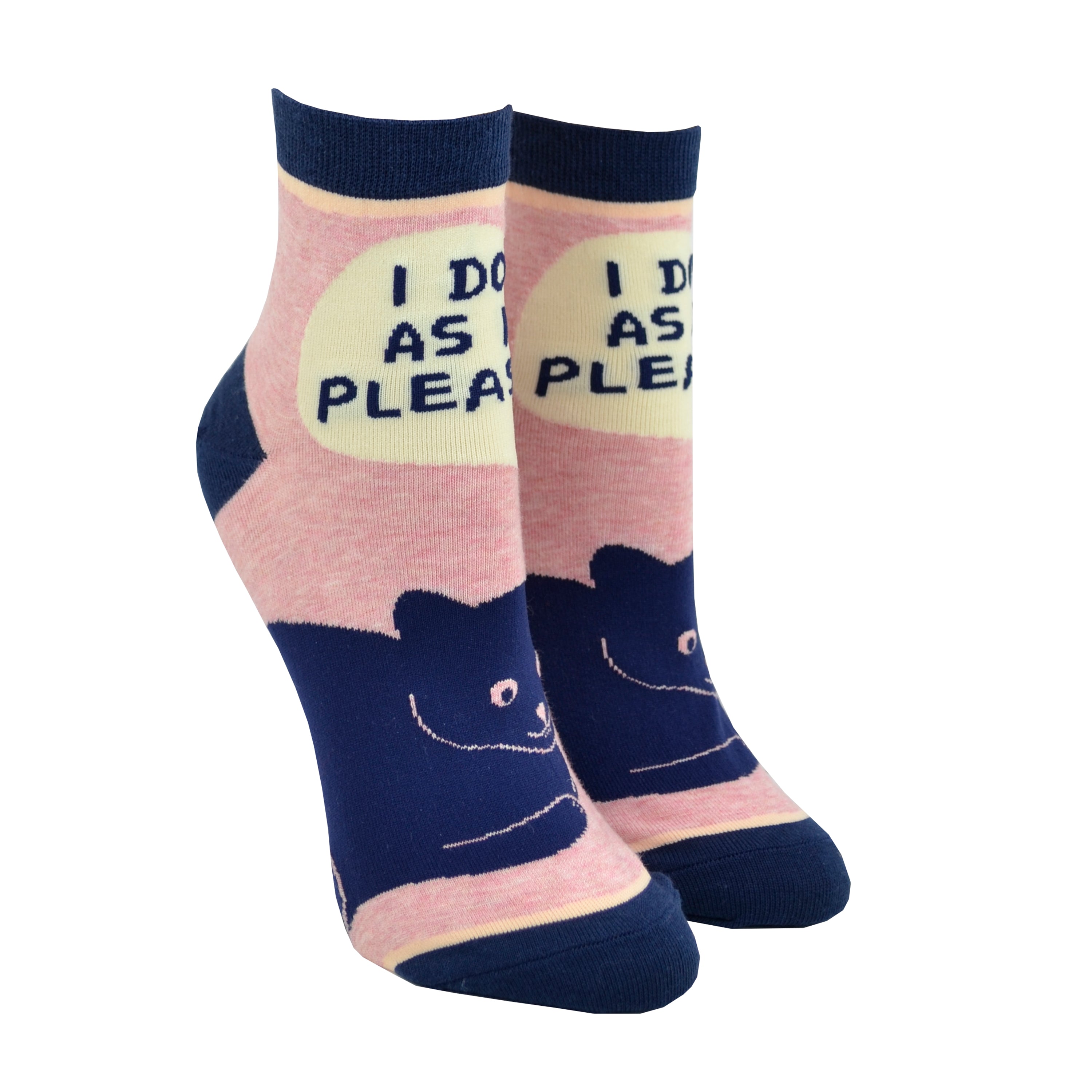 Shown on leg forms, a pair of Blue Q brand women's ankle socks in light pink with a navy blue heel, toe, and cuff. The sock features a blue cartoon cat on the foot with the phrase, 