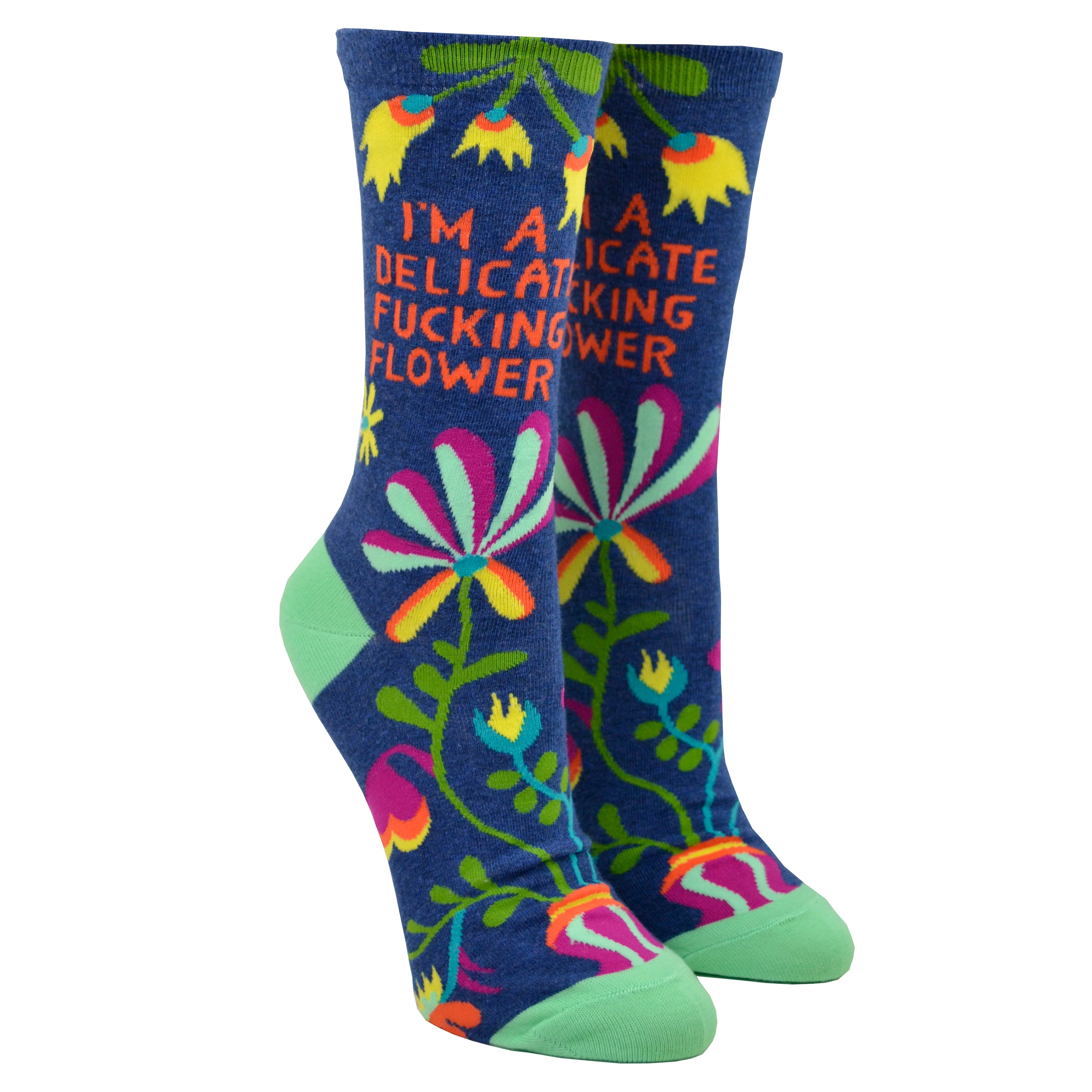 Shown on leg forms from the text side, a pair of Blue Q brand women's nylon and combed cotton socks in navy blue with a teal heel and toe. These socks feature an all over motif of psychedelic inspired flowers and the phrase 