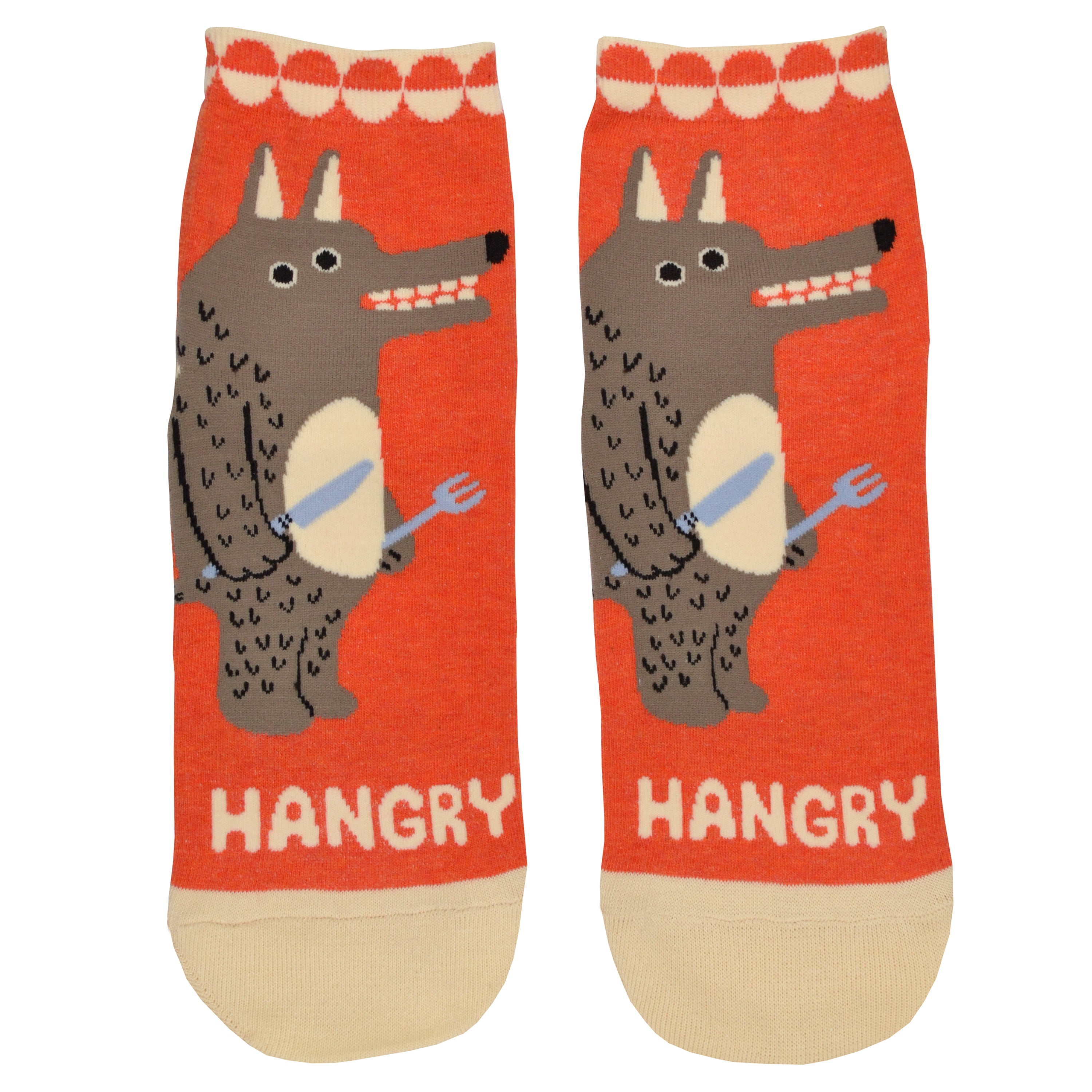Shown in a flatlay, a pair of women's Blue Q cotton ankle socks in orange with a cream heel, toe, and cuff. The front of the socks features a cartoon wolf man with a knife and fork and the word 