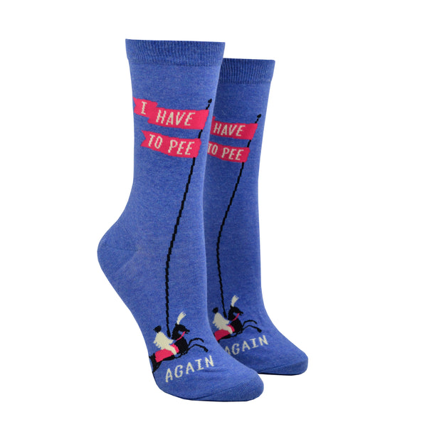 Shown on leg forms, a pair of women's Blue Q brand combed cotton crew sock in blue with a tiny horse rider on the foot of the sock holding a long flagged pole that reads, "I have to pee" on a pink banner. The toe of the sock features the word, "again." underneath the horse rider.