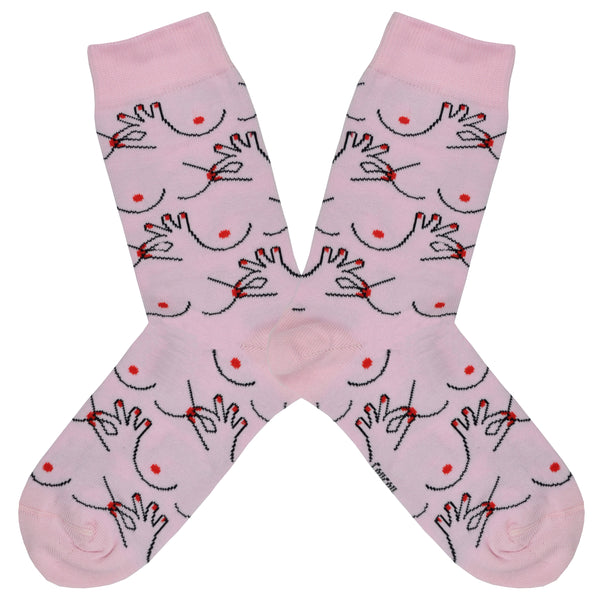 These pink cotton women's crew socks by the brand Coucou Suzette feature bare breasts and a hand pinching one of the nipples.
