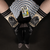 A model in fishnets wears the death tarot socks while a spready of tarot cards lays between them with the death card facing up. 