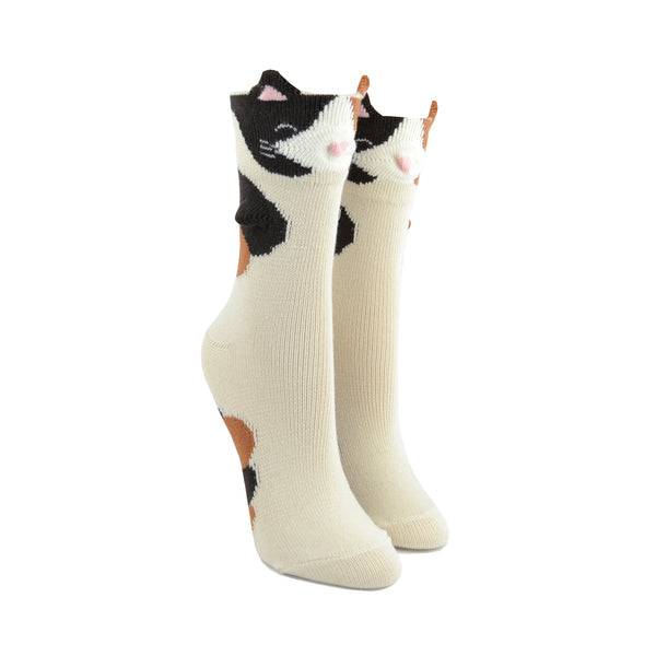 Shown on leg forms, a pair of Foot traffic c3D calico cat socks. These tan socks have a calico print with a 3D  cat face and ears on the cuff. 