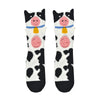 A pair of kids Foot Traffic brand crew length cow socks made of 88% cotton. Each sock features a pink 3D nose and udder.