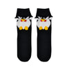 A pair of kids Foot Traffic brand crew length penguin socks made of 88% cotton. Each sock features 3D flippers, nose, and feet.