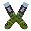 These blue and green cotton men's crew socks with a light blue cuff by the brand Foot Traffic feature an alien spaceship beaming up a cow that was grazing in a field.