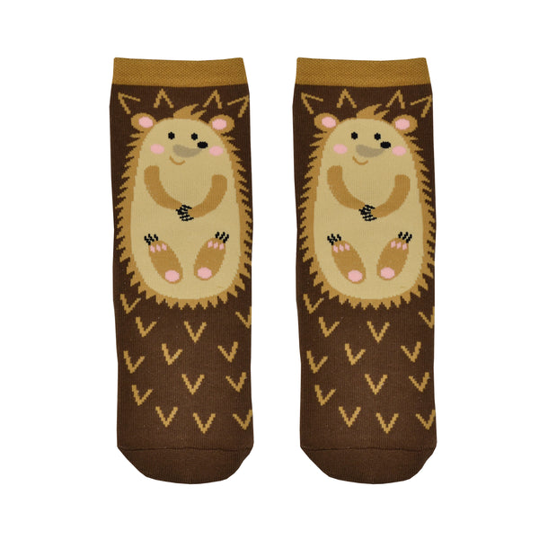 Shown in a flatlay, a pair of women's cotton crew lounge socks by Foot Traffic. These socks are an all over brown with a hedge hog cartoon on the front and they feature a non-skid sole.