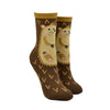 Shown on leg forms, a pair of women's cotton crew lounge socks by Foot Traffic. These socks are an all over brown with a hedge hog cartoon on the front and they feature a non-skid sole.