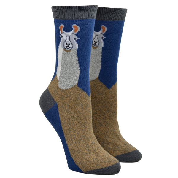 Shown on leg forms, a pair of women's crew socks with a grey heel, toe, and cuff. The leg of the sock features a llama face and neck on a navy blue background while the foot of the sock is brown with a navy blue sole. 