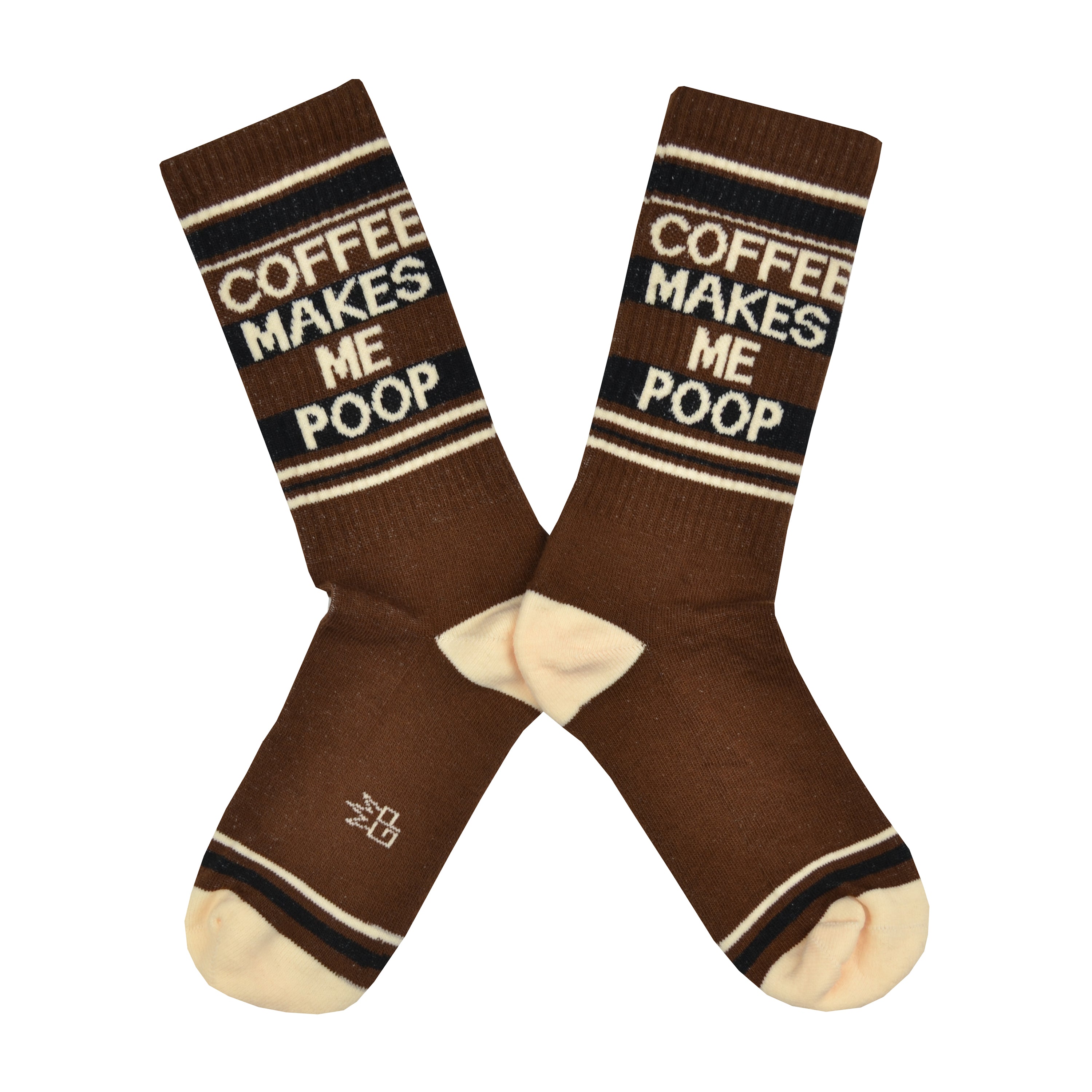 Shown in a flatlay, a pair of Gumball Poodle, dark brown cotton crew socks with tan heel/toe/accent stripes and “Coffee Makes Me Poop” text