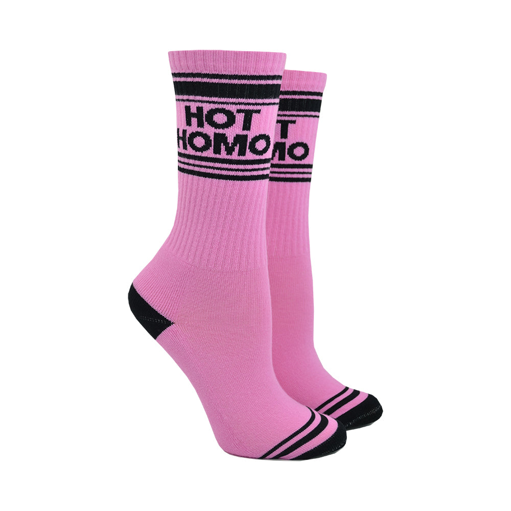Shown on leg forms, a pair of pink cotton Gumball Poodle brand unisex crew socks with black striped toe and cuff. These socks feature the words, 