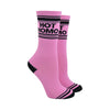 Shown on leg forms, a pair of pink cotton Gumball Poodle brand unisex crew socks with black striped toe and cuff. These socks feature the words, "HOT HOMO" on the leg in black.